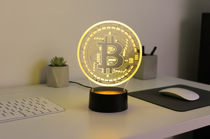 Bitcoin-themed lamp on a desk with a keyboard and mouse pad in the background