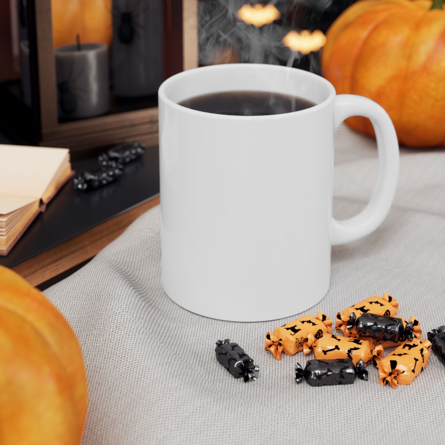 White mug with steaming coffee on a table with Halloween-themed cookies and pumpkins in the background.