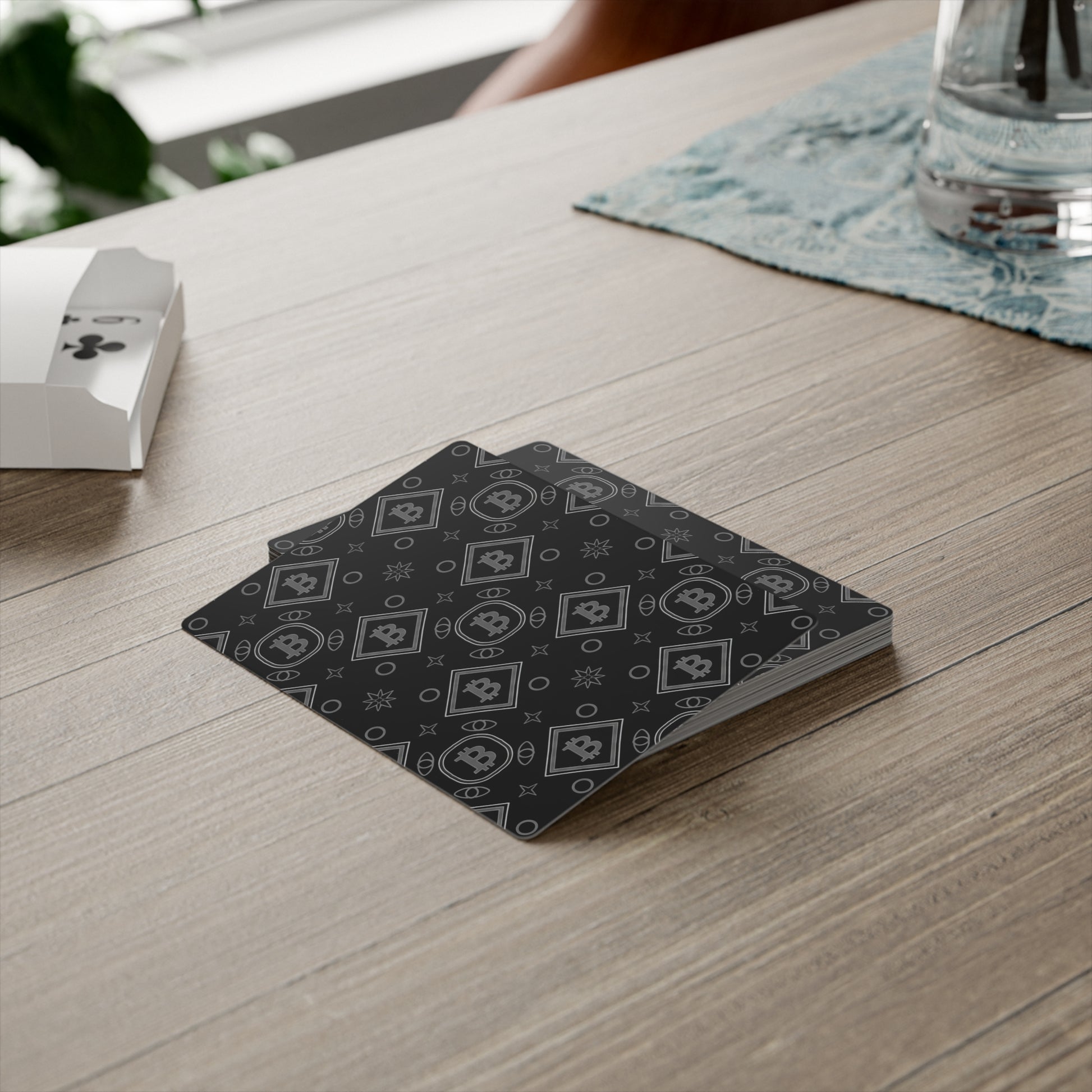 Stack of playing cards with a black and white pattern on a wooden table.