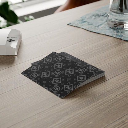 Stack of playing cards with a black and white pattern on a wooden table.