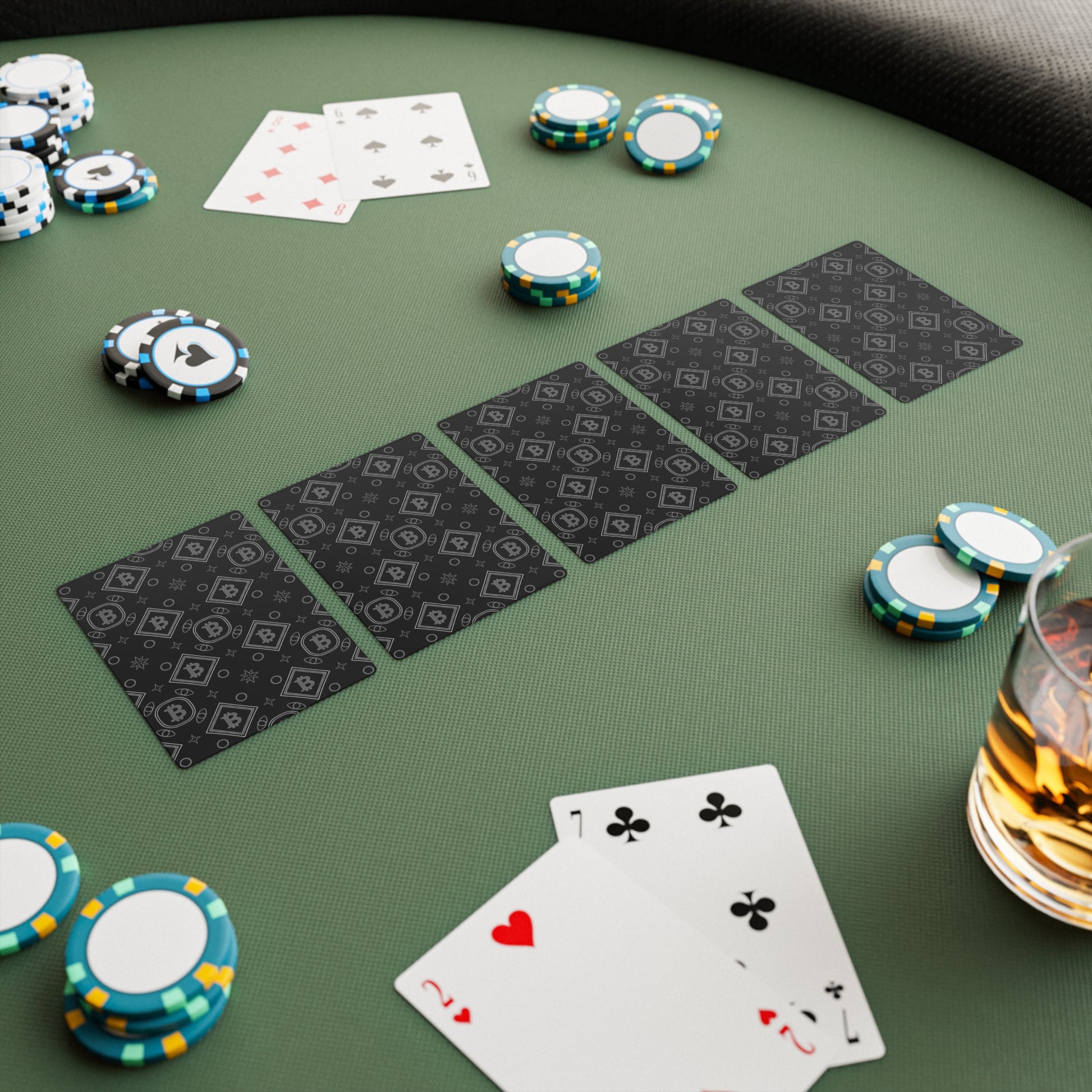 Poker game setup with cards and chips on a green table.
