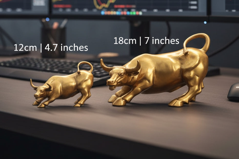 Two gold bull figurines with measurements on a desk