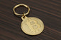 Gold Bitcoin keychain on a wooden surface