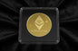Gold Ethereum coin in a clear case on a black background
