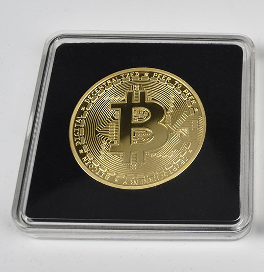 Gold Bitcoin coin in a clear protective case on a white background