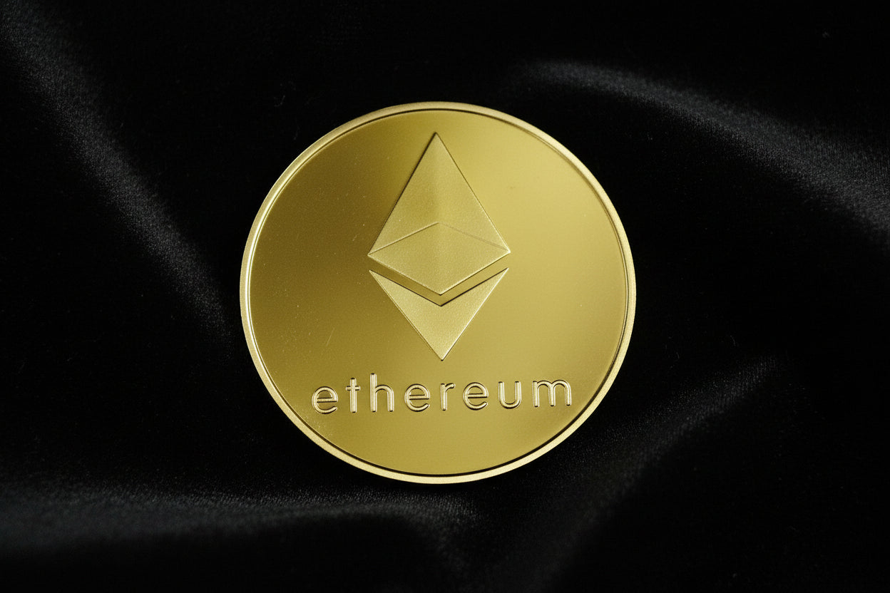Gold Ethereum coin on black fabric