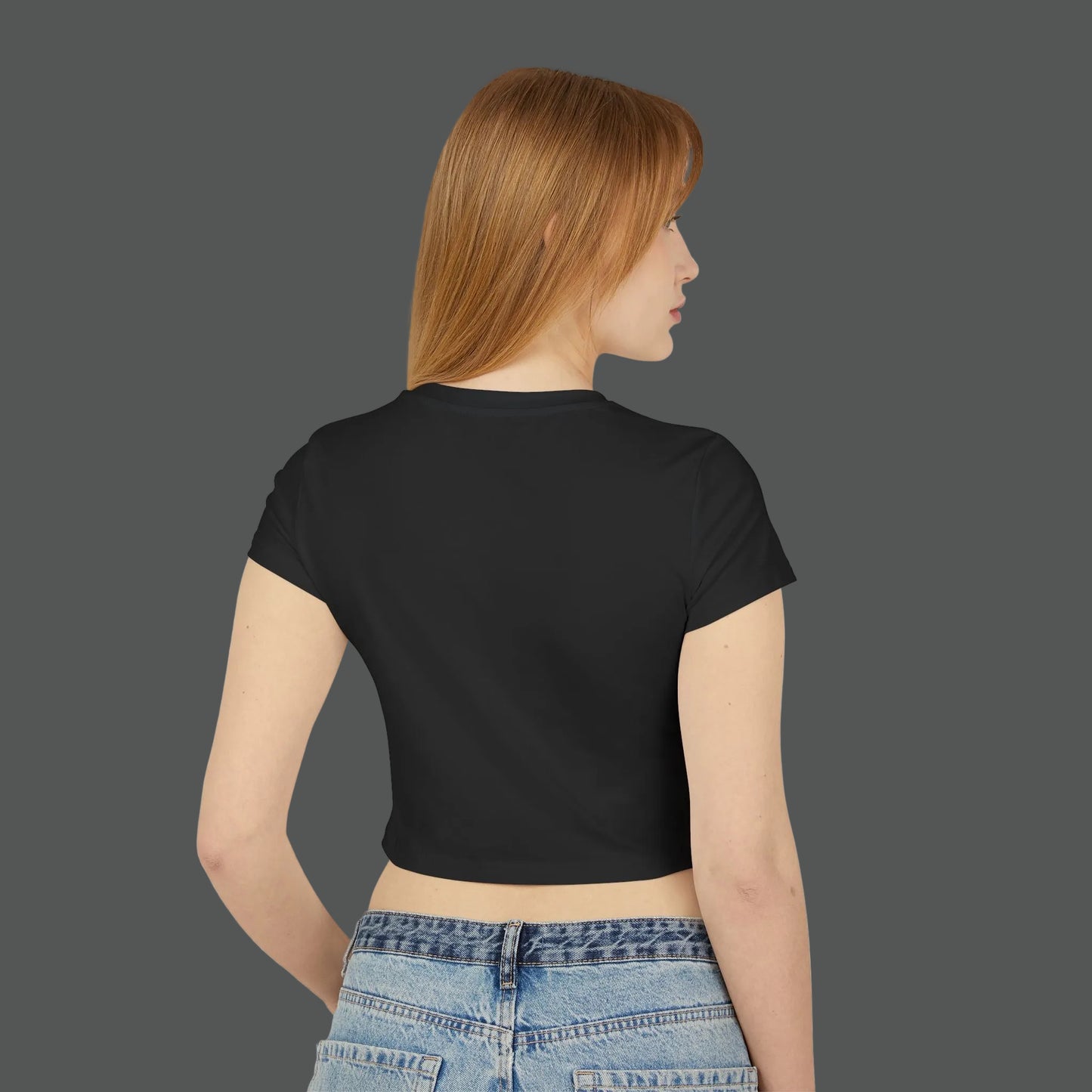 Person wearing a black crop top and blue jeans on a white background