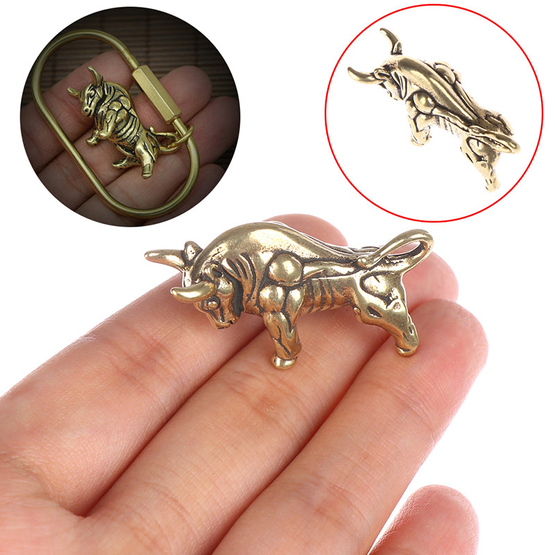 Gold bull-shaped object held in a hand with close-up inset showing details.