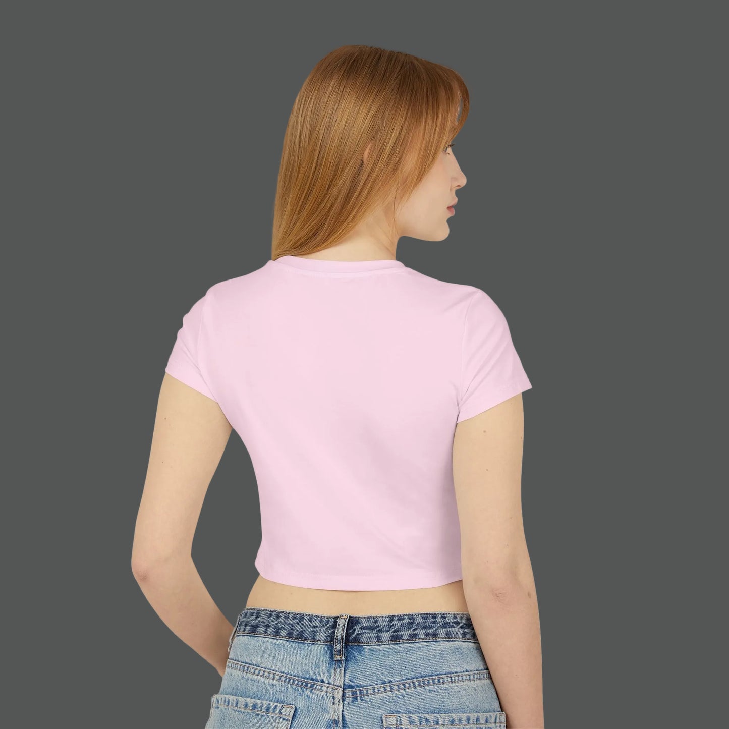 Woman wearing a pink crop top and blue jeans on a white background