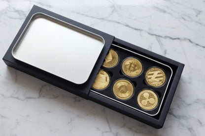 Set of gold coins in a black box on a marble background