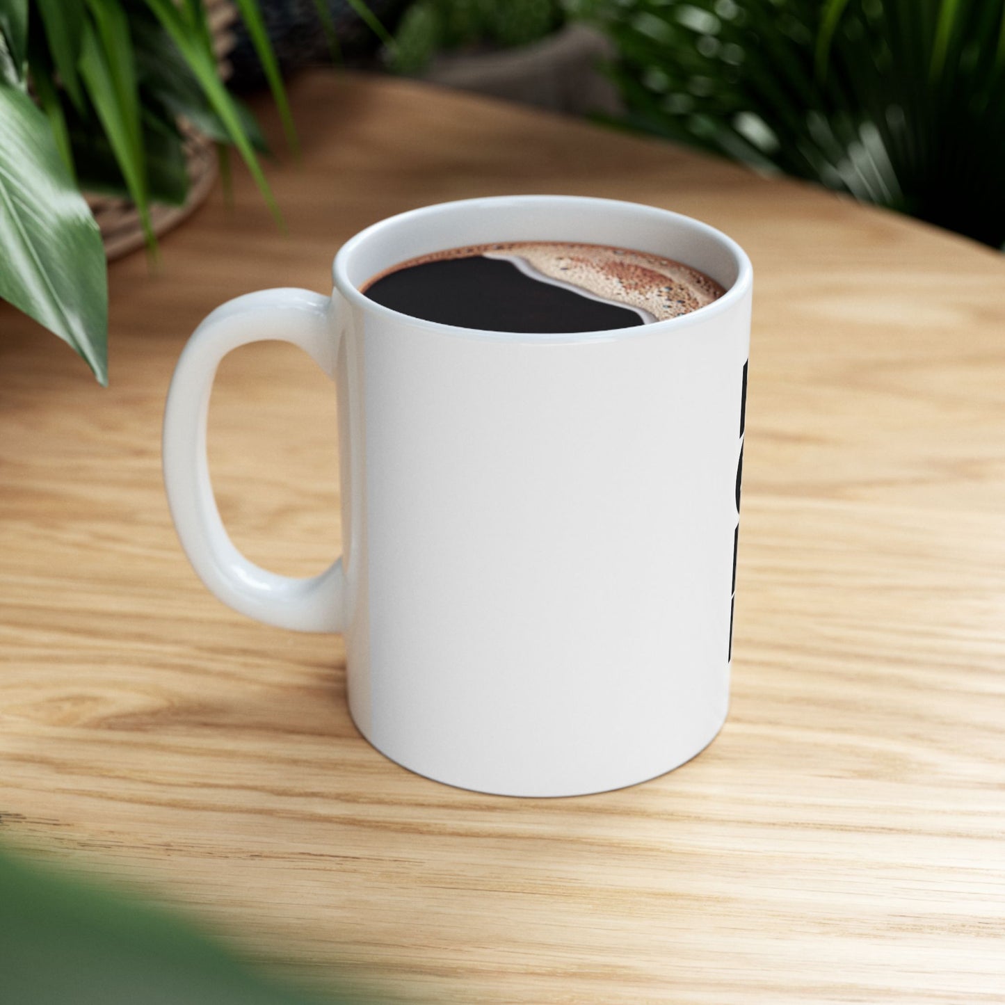 White mug with coffee on a wooden table with plants in the background