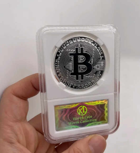 Silver Bitcoin coin in a protective case held by a hand on a white background