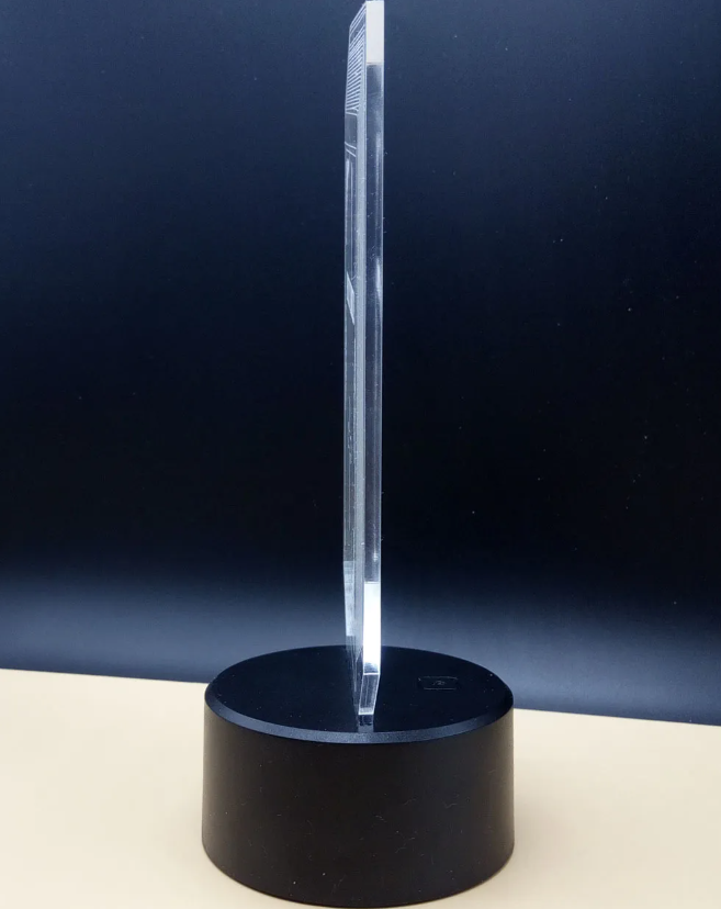 Clear crystal object on a black base against a dark blue background